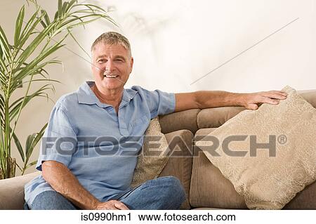 Stock Image - Senior man sitting on sofa. Fotosearch