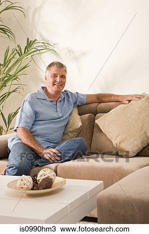 Senior man sitting on sofa View Large Photo Image Stock Image - Senior man sitting on sofa. Fotosearch