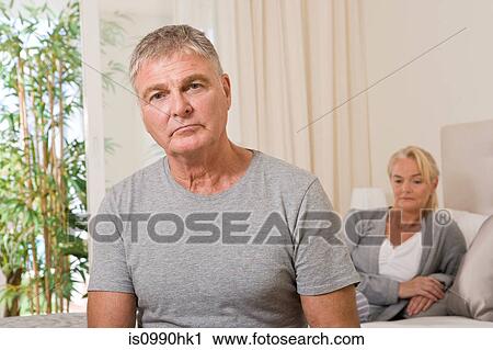 Stock Image - Worried couple in bedroom. Fotosearch