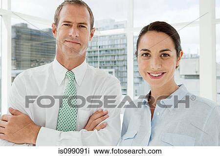 Stock Image - Businessman and businesswoman in office, portrait. Fotosearch