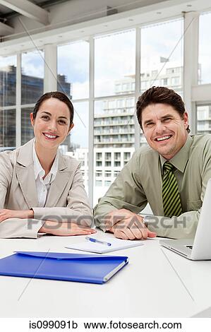 Stock Image - Businessman and businesswoman meeting in office. Fotosearch