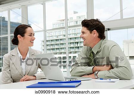 Businessman and businesswoman meeting in office with laptop View Large Photo Image Stock Photo - Businessman and businesswoman meeting in office with laptop. Fotosearch