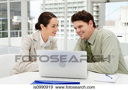 Stock Photo - Businessman and businesswoman meeting in office with laptop. Fotosearch