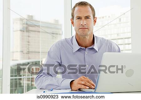 Businessman using laptop in office View Large Photo Image Stock Image - Businessman using laptop in office. Fotosearch