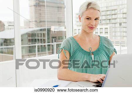 Businesswoman using laptop in office View Large Photo Image Stock Image - Businesswoman using laptop in office. Fotosearch