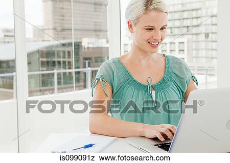 Businesswoman using laptop in office View Large Photo Image Stock Photo - Businesswoman using laptop in office. Fotosearch