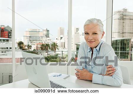 Mature businesswoman in office with laptop View Large Photo Image Stock Image - Mature businesswoman in office with laptop. Fotosearch