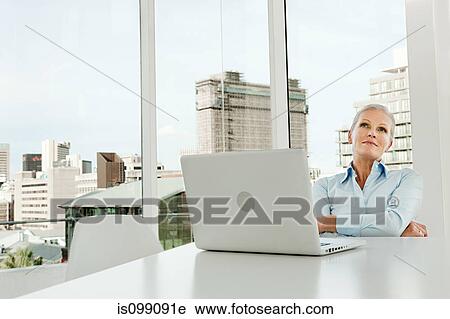 Mature businesswoman in office with laptop View Large Photo Image Stock Image - Mature businesswoman in office with laptop. Fotosearch