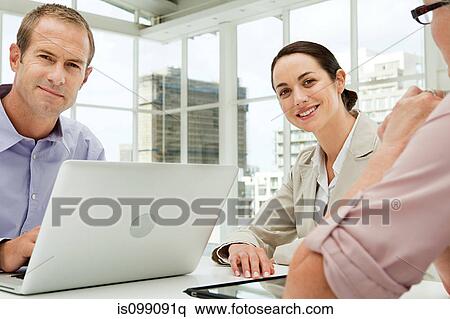 Three businesspeople meeting in office using laptop View Large Photo Image Stock Photography - Three businesspeople meeting in office using laptop. Fotosearch
