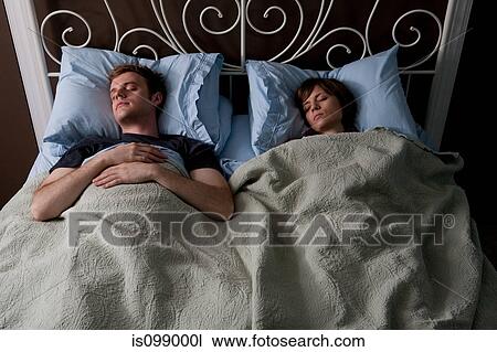 Stock Image - Young couple asleep in bed. Fotosearch
