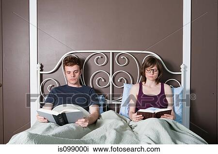Young couple reading in bed View Large Photo Image Stock Image - Young couple reading in bed. Fotosearch