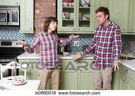 Young couple shrugging in kitchen View Large Photo Image Stock Photo - Young couple shrugging in kitchen. Fotosearch