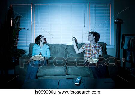 Young couple throwing popcorn and catching it in mouth View Large Photo Image Stock Photograph - Young couple throwing popcorn and catching it in mouth. Fotosearch