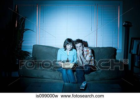 Young couple watching tv, man biting fingernails View Large Photo Image Stock Photo - Young couple watching tv, man biting fingernails. Fotosearch