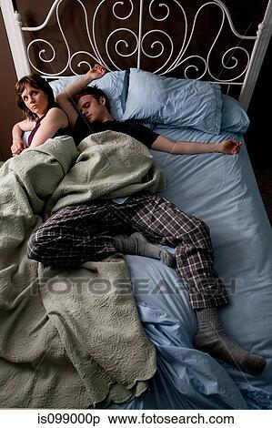 Young man asleep, woman squashed to the edge of bed View Large Photo Image Stock Photography - Young man asleep, woman squashed to the edge of bed. Fotosearch