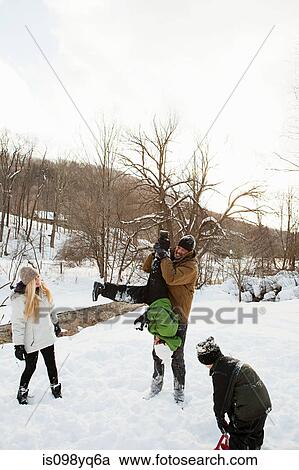 Stock Image - Family playing in snow. Fotosearch