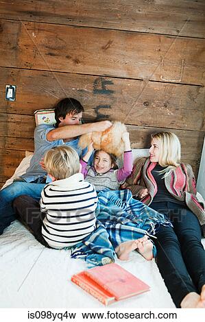 Stock Photo - Family playing on bed. Fotosearch