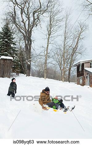 Stock Image - Family sledging in snow. Fotosearch