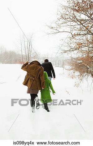 Stock Photo - Family walking in snow. Fotosearch