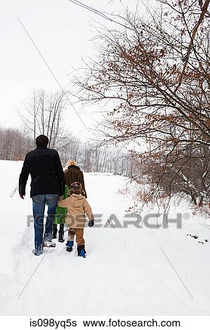 Stock Photograph - Family walking in snow. Fotosearch