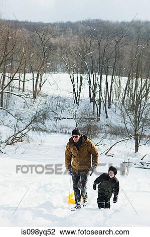 Father and son sledging on snow View Large Photo Image Stock Image - Father and son sledging on snow. Fotosearch