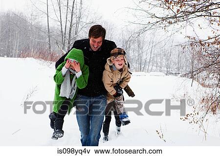 Father carrying son and daughter in snow View Large Photo Image Stock Photo - Father carrying son and daughter in snow. Fotosearch