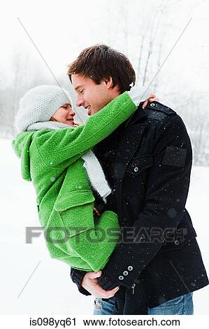 Father holding daughter in snow View Large Photo Image Stock Image - Father holding daughter in snow. Fotosearch