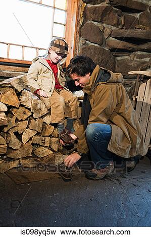 Father putting shoes on son View Large Photo Image Stock Photo - Father putting shoes on son. Fotosearch