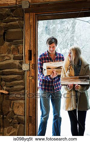 Mid adult couple holding logs View Large Photo Image Stock Photograph - Mid adult couple holding logs. Fotosearch