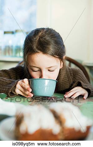 Picture - Young girl drinking hot drink. Fotosearch