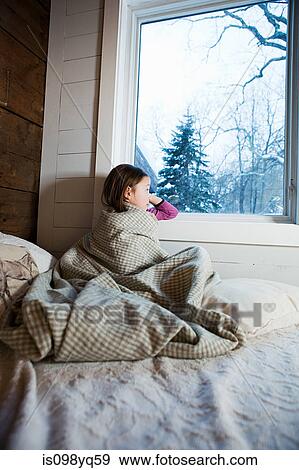 Young girl sitting on bed looking through window View Large Photo Image Stock Photo - Young girl sitting on bed looking through window. Fotosearch