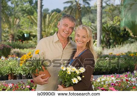 Couple with plants in garden centre View Large Photo Image Stock Image - Couple with plants in garden centre. Fotosearch