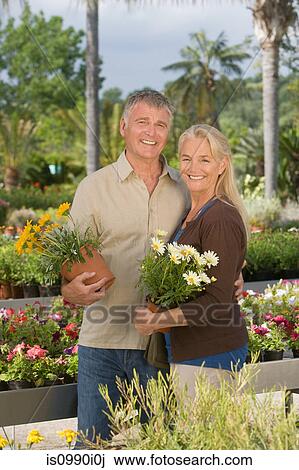 Couple with plants in garden centre View Large Photo Image Stock Image - Couple with plants in garden centre. Fotosearch