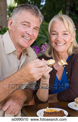 Mature couple having cake View Large Photo Image Stock Image - Mature couple having cake. Fotosearch