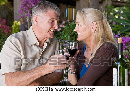 Stock Image - Mature couple having red wine. Fotosearch