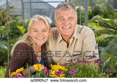 Mature couple with flowers in garden centre View Large Photo Image Stock Photo - Mature couple with flowers in garden centre. Fotosearch