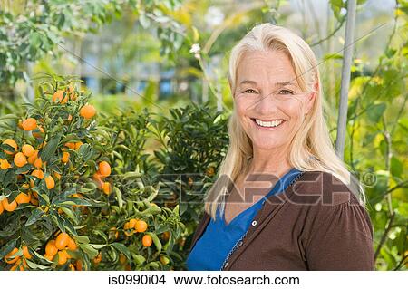Mature woman by fruit tree View Large Photo Image Picture - Mature woman by fruit tree. Fotosearch
