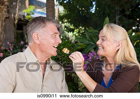Mature woman feeding cake to husband View Large Photo Image Stock Image - Mature woman feeding cake to husband. Fotosearch