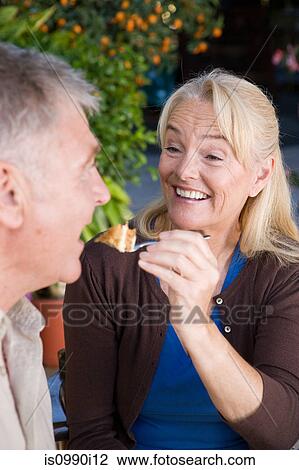Mature woman feeding cake to husband View Large Photo Image Stock Image - Mature woman feeding cake to husband. Fotosearch