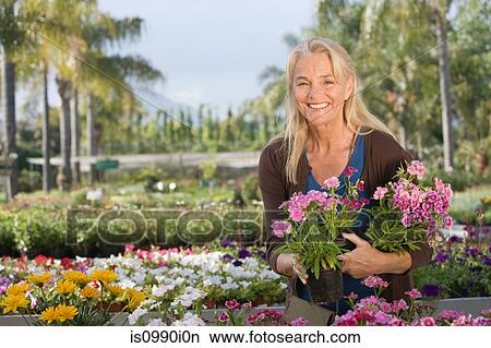 Woman with flowers at garden centre View Large Photo Image Picture - Woman with flowers at garden centre. Fotosearch