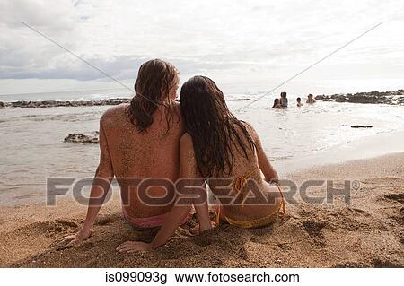 Couple sitting on sand, rear view View Large Photo Image Stock Image - Couple sitting on sand, rear view. Fotosearch