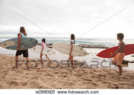 Four young friends carrying surfboards on beach View Large Photo Image Stock Image - Four young friends carrying surfboards on beach. Fotosearch