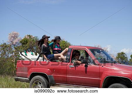 Picture - Three young friends driving off road vehicle on vacation. Fotosearch