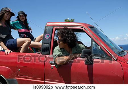 Stock Photography - Three young friends driving off road vehicle on vacation. Fotosearch
