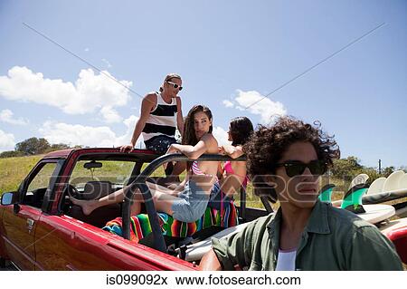 Stock Photo - Three young friends in off road vehicle on vacation. Fotosearch