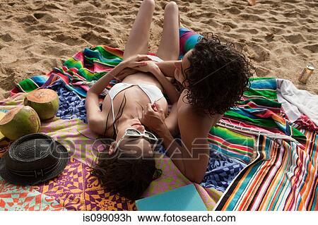 Stock Image - Young couple lying on beach resting. Fotosearch