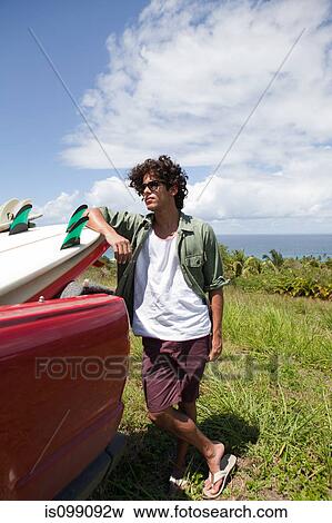 Young man leaning against surfboard in car, portrait View Large Photo Image Stock Photo - Young man leaning against surfboard in car, portrait. Fotosearch