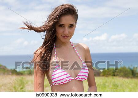 Stock Photo - Young woman wearing pink and white stripe bikini, portrait. Fotosearch