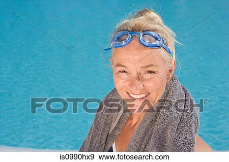 Stock Photo - Mature woman by swimming pool. Fotosearch