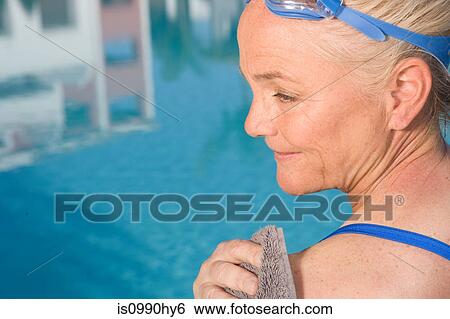 Stock Photograph - Mature woman by swimming pool. Fotosearch